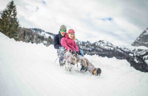 Ein Pärchen auf einem Rodel in der Familien-Skiregion St. Johann in Tirol